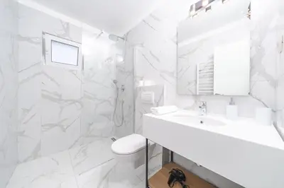 a white bathroom with a sink and a toilet at Apartments Mara Lux in Budva