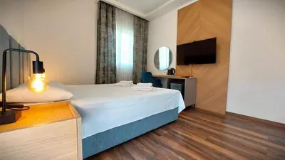 a hotel room with a bed and a flat screen tv at Apartments Mara Lux in Budva