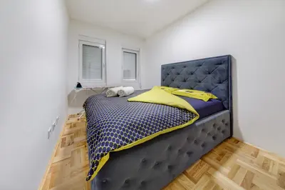 a bedroom with a large bed with yellow pillows at Apartment Makao in Podgorica