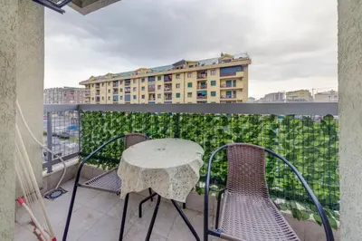a table and chairs on a balcony with a building at Apartment Makao in Podgorica