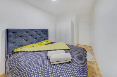 a bedroom with a blue and yellow bed with towels on it at Apartment Makao in Podgorica