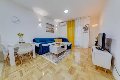 a living room with a blue couch and a table at Apartment Makao in Podgorica