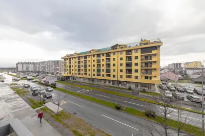a yellow building on the side of a city street at Apartment Makao in Podgorica