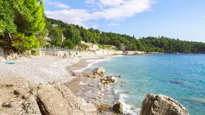 a beach with rocks and people in the water at Golden bay in Bar