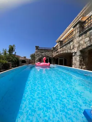 a large swimming pool with a red float in the middle at Vila Reževići in Budva