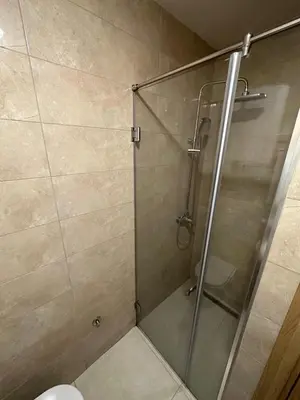 a shower with a glass door in a bathroom at Irina Centre apartment in Podgorica