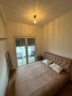 a bedroom with a large bed with a large window at Irina Centre apartment in Podgorica