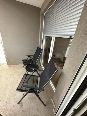 two chairs sitting on a balcony next to a window at Irina Centre apartment in Podgorica