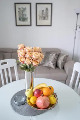 a vase filled with roses and fruit on a table at Apartment Adriana in Kotor