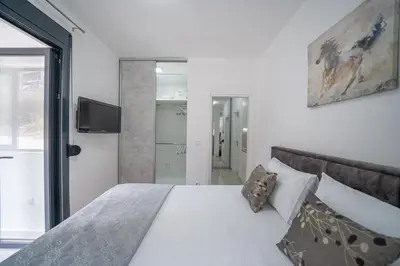 a bedroom with a white bed and a tv at Apartment Adriana in Kotor