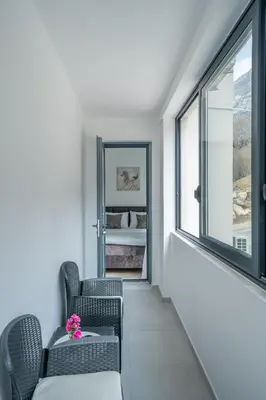 a hallway with chairs and a window and a bedroom at Apartment Adriana in Kotor