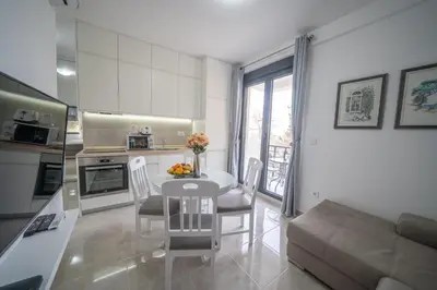 a kitchen and living room with a table and a couch at Apartment Adriana in Kotor