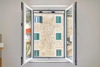a window with a view of a building at Symphony Apartments Street View in Petrovac na Moru