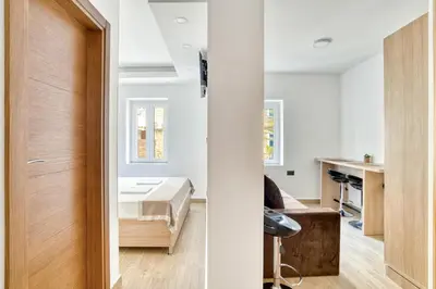 a bedroom with a bed and a desk in a room at Symphony Apartments Street View in Petrovac na Moru