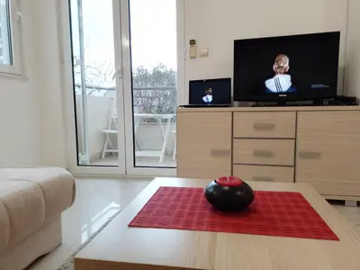 a living room with a tv and a table at Splendid studio apartment in Becici