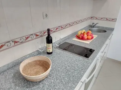 a bottle of wine and a bowl of fruit on a kitchen counter at Splendid studio apartment in Becici