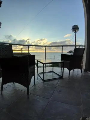 a patio with chairs and a table and a view of the ocean at Summer Beach House in Ulcinj