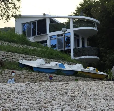 a house with a boat in front of it at Summer Beach House in Ulcinj