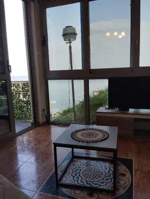 a living room with a table and a view of a lighthouse at Summer Beach House in Ulcinj