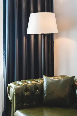 a lamp sitting next to a couch in a room at Bristol Hotel Podgorica in Podgorica
