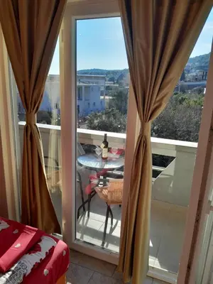 a room with a window with a table on a balcony at Perper in Sutomore