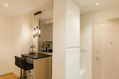 a small kitchen with a black chair in a room at Luxury AMAAA Apartment in Bar