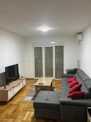 a living room with a couch and a tv at SKY Apartment in Budva