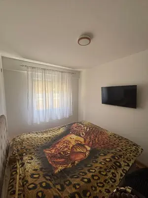 a bedroom with a bed with a painting on it at SKY Apartment in Budva