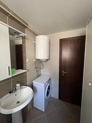 a bathroom with a sink and a washing machine at SKY Apartment in Budva