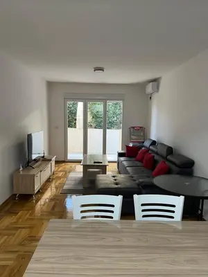 a living room with a couch and a table and chairs at SKY Apartment in Budva