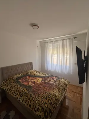 a bedroom with a bed with a leopard print blanket at SKY Apartment in Budva