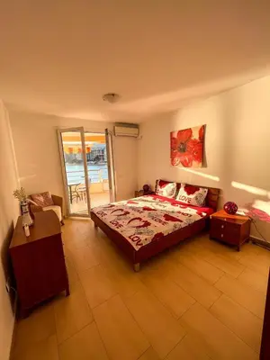 a bedroom with a large bed and a balcony at Luxury Apartment Astelmn in Budva