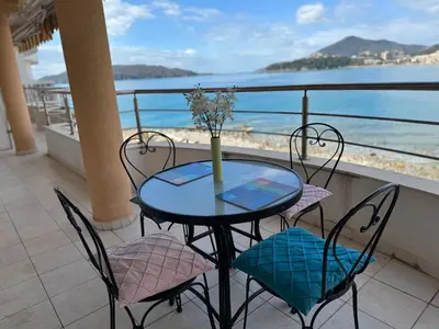 a table and chairs on a balcony with the beach at Luxury Apartment Astelmn in Budva