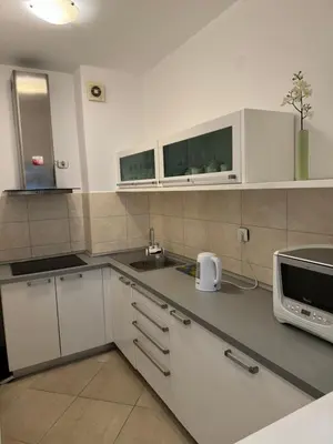 a kitchen with white cabinets and a microwave at Luxury Apartment Astelmn in Budva