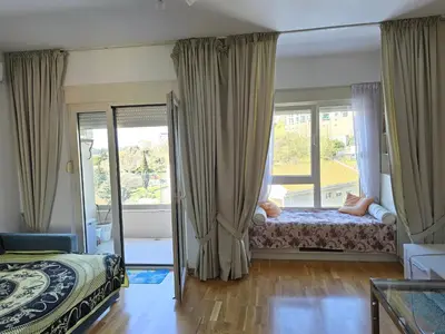a bedroom with a bed and a large window at Стильная квартира с видом на море и библиотекой in Becici