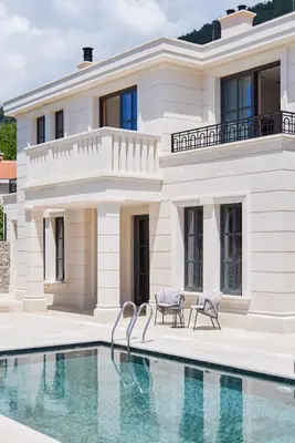 a villa with a swimming pool in front of a house at Eterno Villas in Budva