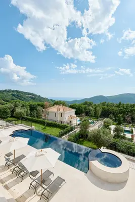 a pool with chairs and umbrellas and a building at Eterno Villas in Budva