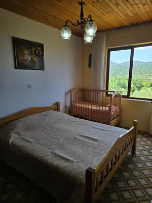 a bedroom with a bed and a couch and a window at Rustic House Montenegro in Bar
