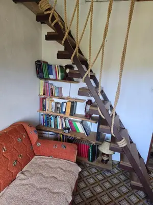 a room with a bed and a book shelf with books at Rustic House Montenegro in Bar