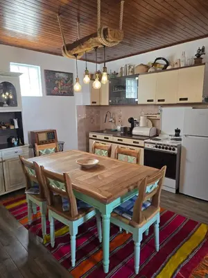 a kitchen with a wooden table and some chairs at Rustic House Montenegro in Bar