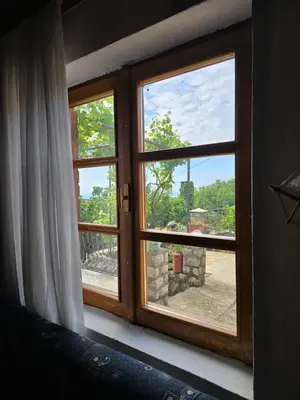 a window in a bedroom with a view of a yard at Rustic House Montenegro in Bar