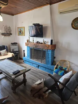 a living room with a fireplace with a tv above it at Rustic House Montenegro in Bar