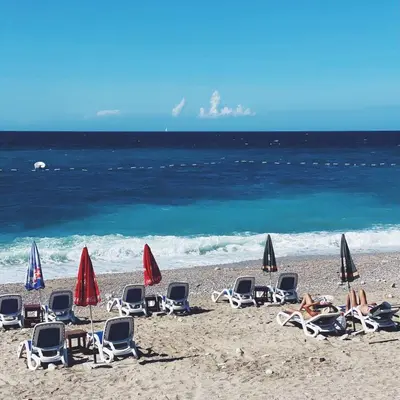 a group of chairs and umbrellas on a beach at Dream Apartments in Dobra Voda