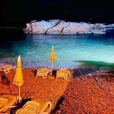 a group of chairs and umbrellas on a beach at Dream Apartments in Dobra Voda