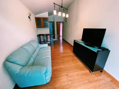 a living room with a blue couch and a flat screen tv at Dream Apartments in Dobra Voda