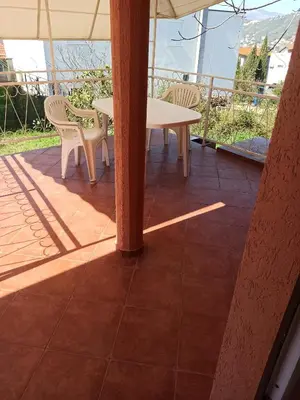 a table and chairs on a patio with an umbrella at Apartment Dubrava 112 in Dobra Voda