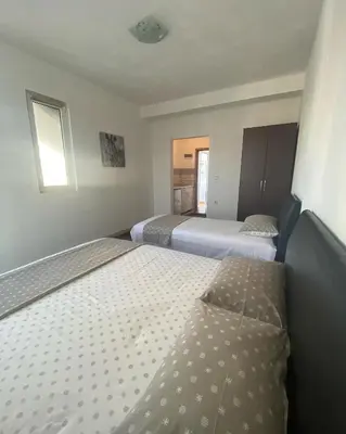 a hotel room with two beds and two windows at Ajan Apartments in Ulcinj