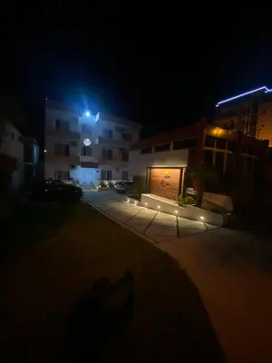 a shadow of a person in front of a building at night at Ajan Apartments in Ulcinj