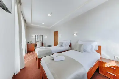 a bedroom with two beds with white sheets at Casa Costa in Dobra Voda