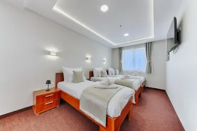 a hotel room with three beds and a window at Casa Costa in Dobra Voda